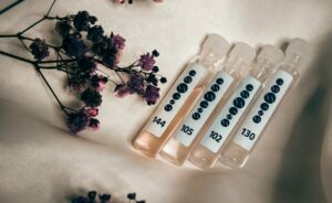 Four perfume samples on silk fabric with dried flowers creating a vintage allure.